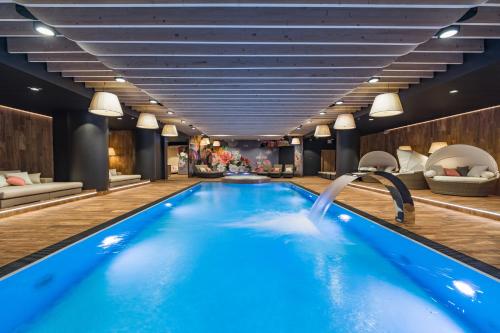 シュツァブニツァにあるSzczawnica Park Resort & Spaのウォータースライダー付きのホテル内のプール