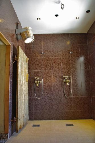 a bathroom with a shower with two shower heads at Torma Puhkemaja ja Glämping in Torma