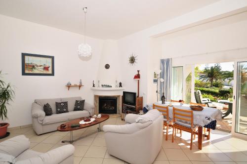 a living room with white furniture and a fireplace at VIVENDA JOHANNA in Lagos