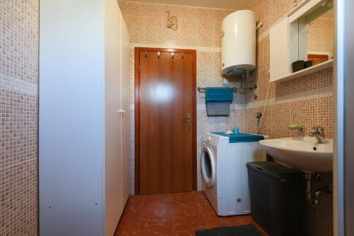 a bathroom with a washing machine and a sink at Apartman Croatia Zadar in Zadar