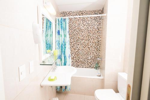 a white bathroom with a sink and a shower at Soho Point in Buenos Aires