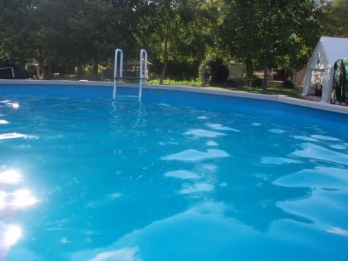 a large pool with blue water in a yard at Le Cormier in Obterre