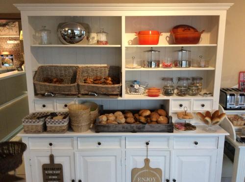 a pantry filled with lots of baskets of food at Boutique Hotel Butler in Zuienkerke