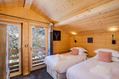 モルジヌにあるSimply Morzine - Chalet Petit Centralのベッド2台 木製の壁の部屋