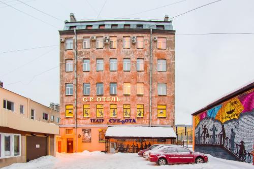 een rode auto geparkeerd voor een gebouw bij Hotel Golden Palace in Sint-Petersburg