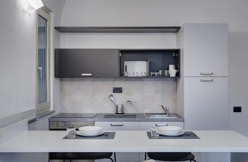 a kitchen with a sink and a counter with stools at QUADRATO in Turin