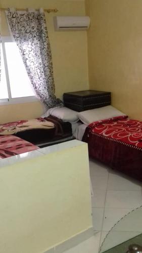 a room with two beds and a window at Hôtel Tijani in Fès