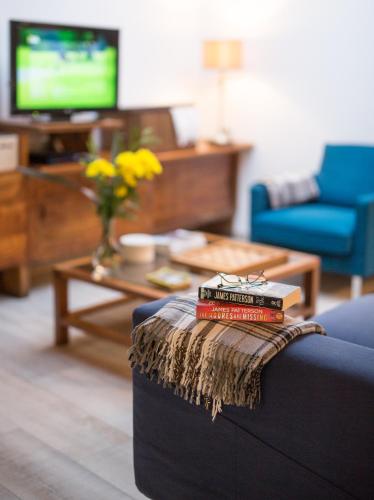 a stack of books sitting on a couch in a living room at Hotel Alcides in Ponta Delgada