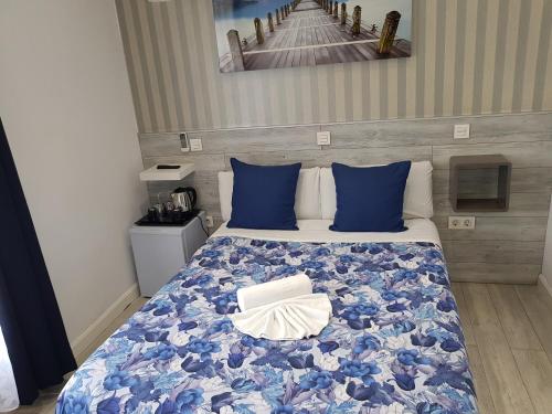 a bedroom with a bed with blue pillows at Hostal Main Street Madrid in Madrid
