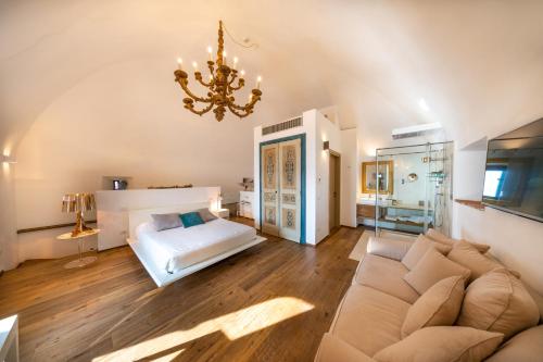 a living room with a couch and a chandelier at Torre Mozza - Dimora d' Epoca in Follonica