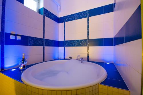 布爾諾的住宿－Penzion Hády，蓝色和白色的浴室配有浴缸
