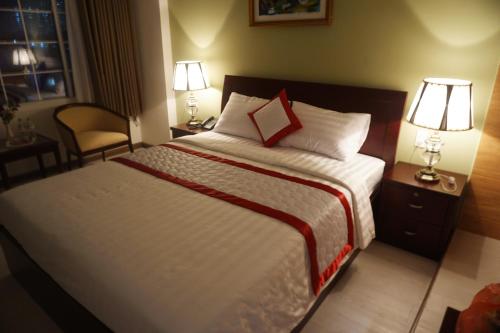 a hotel room with a large bed with two lamps at Hue My Hotel in Ho Chi Minh City