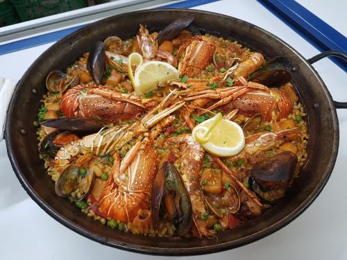 a pan of food with shrimp and mussels at Hotel La Cala in Roses
