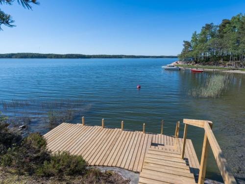 a dock on a lake with a boat in the water at Holiday Home Lokki by Interhome in Karuna