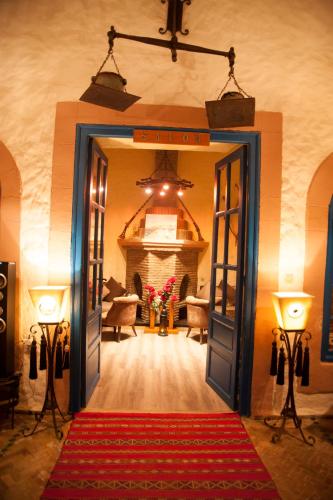 a hallway with a room with a red rug and two lights at Riad Al Madina in Essaouira