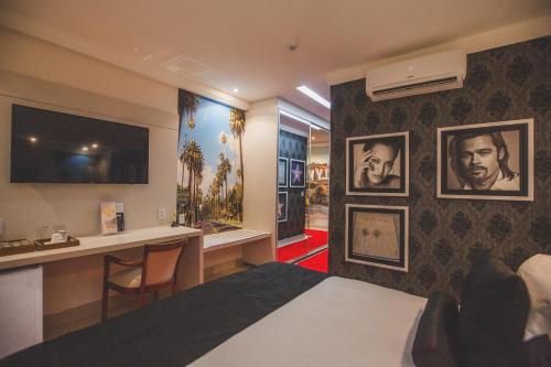 a hotel room with a bed and a desk at Golden Lis Hotel Boutique in Goiânia