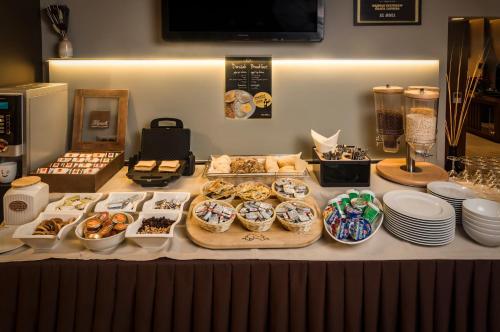 a table topped with different types of pastries and desserts at Hotel Residence in Zagreb