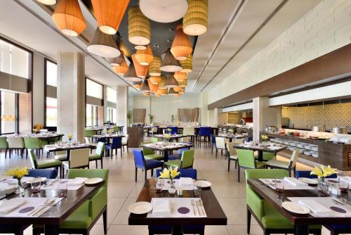 an image of a restaurant with tables and chairs at Novotel Imagicaa Khopoli in Khopoli
