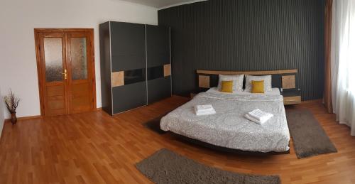 a bedroom with a bed and a wooden floor at Premium Central Apartment in Oradea