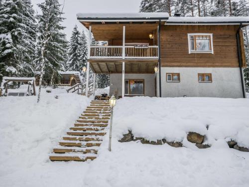 une cabane en rondins dans la neige avec des escaliers enneigés dans l'établissement Holiday Home Mäntyrinne by Interhome, à Havumäki