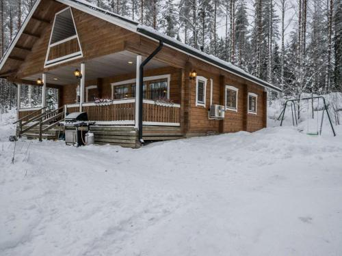 HavumäkiにあるHoliday Home Salmensuu by Interhomeの雪の森の丸太小屋
