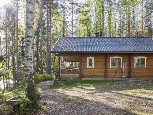 a log cabin in the woods with a porch at Holiday Home Salmensuu by Interhome in Havumäki