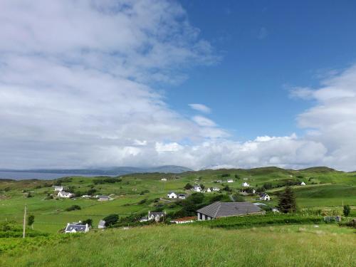 un groupe de maisons sur une colline verdoyante dans l'établissement Holiday Home Tarskavaig by Interhome, à Tarskavaig