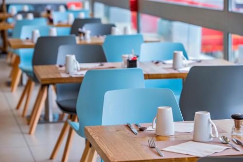 a row of tables and blue chairs in a restaurant at Mercure Paris Vaugirard Porte De Versailles in Paris