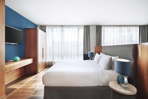 una camera con un grande letto bianco e una TV di Metropol Palace, Belgrade a Belgrado