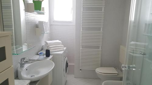 La salle de bains blanche est pourvue d'un lavabo et de toilettes. dans l'établissement le stanze del Trenino Rosso, à Tirano
