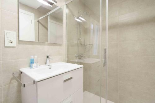bagno con lavandino bianco e doccia di The Rentals Collection | Verona a San Sebastián