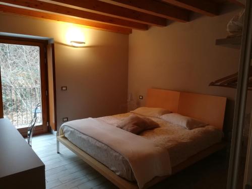 a bedroom with a bed and a large window at Lago d'Orta Appartamento con vista in Pettenasco
