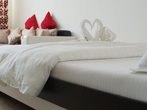 two beds with white sheets and red pillows at Studio Central in Piatra Neamţ