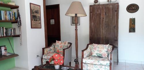 a living room with a chair and a lamp at Casarão Villa al Mare in Ubatuba