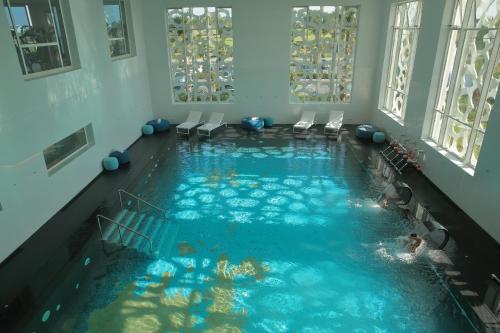 an indoor swimming pool with chairs in a building at The View Bouznika in Bouznika