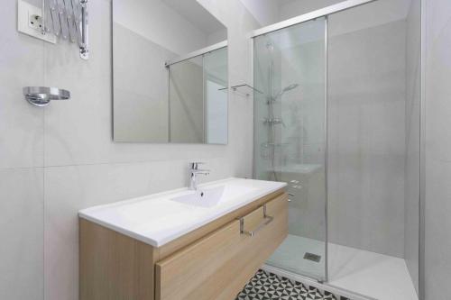 a bathroom with a sink and a glass shower at The Rentals Collection | Okendo I in San Sebastián