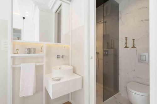 bagno bianco con lavandino e servizi igienici di The Rentals Collection | Scala a San Sebastián