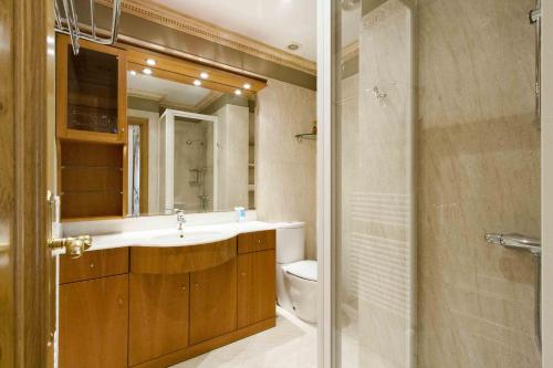 W łazience znajduje się umywalka, toaleta i lustro. w obiekcie The Rentals Collection | Camelot w mieście San Sebastián