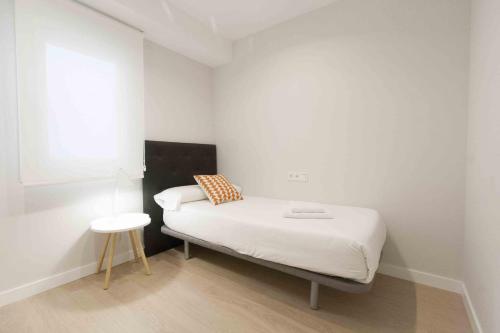una piccola camera con letto e sgabello di The Rentals Collection | Verona a San Sebastián