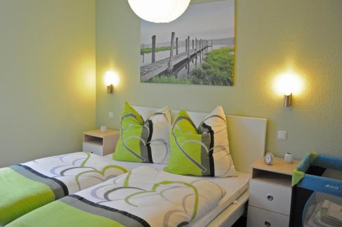a bedroom with two beds with green and white pillows at Ferienhaus Müritzidyll / EG-Appartement in Marienfelde