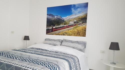 una camera da letto con un letto e un dipinto sul muro di le stanze del Trenino Rosso a Tirano