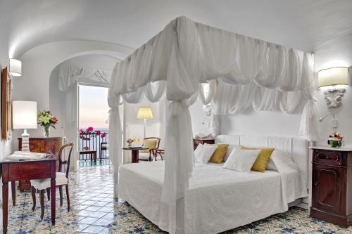 a bedroom with a white bed with a canopy at Hotel Santa Caterina in Amalfi