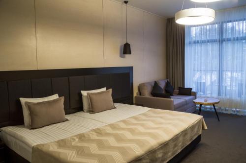 a bedroom with a bed and a couch and a chair at Sobi Hotel in Vyshhorod