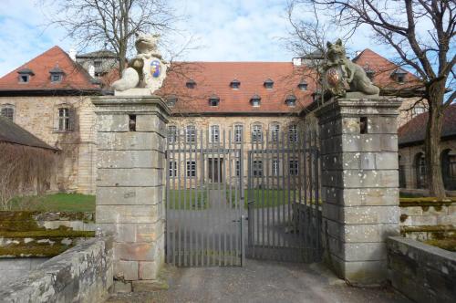 an entrance to an old building with a gate with statues of animals at Ferienzimmer im Schloss Burgpreppach in Burgpreppach