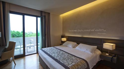 a hotel room with a bed and a large window at Galzignano Resort Terme & Golf - Hotel Majestic in Galzignano