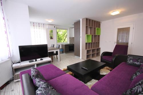 a living room with a purple couch and a table at Sarajevo Apartments in Sarajevo