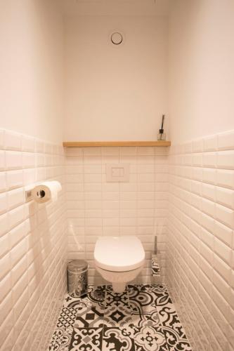a bathroom with a toilet and a tile floor at De Sjeiven Dorpel in Maaseik