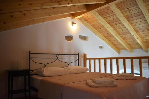 a bedroom with a bed with two towels on it at Christos Raches traditional houses in Raches