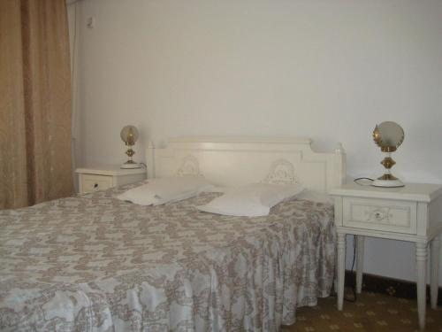a bedroom with a bed with two nightstands and two lamps at Hotel Traian Eforie Nord in Eforie Nord