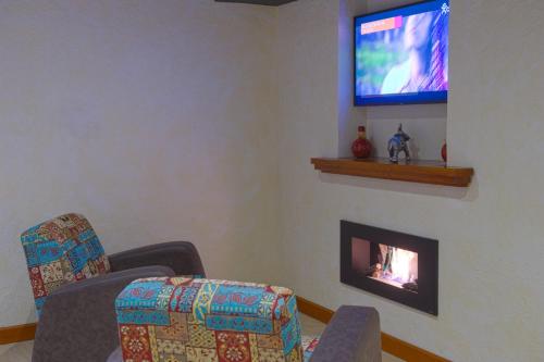 a living room with two chairs and a fire place at Spa Hotel Spartak in Sandanski